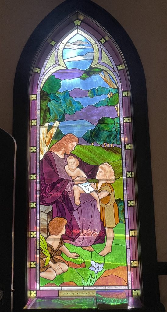Stained glass window depicting Jesus and children