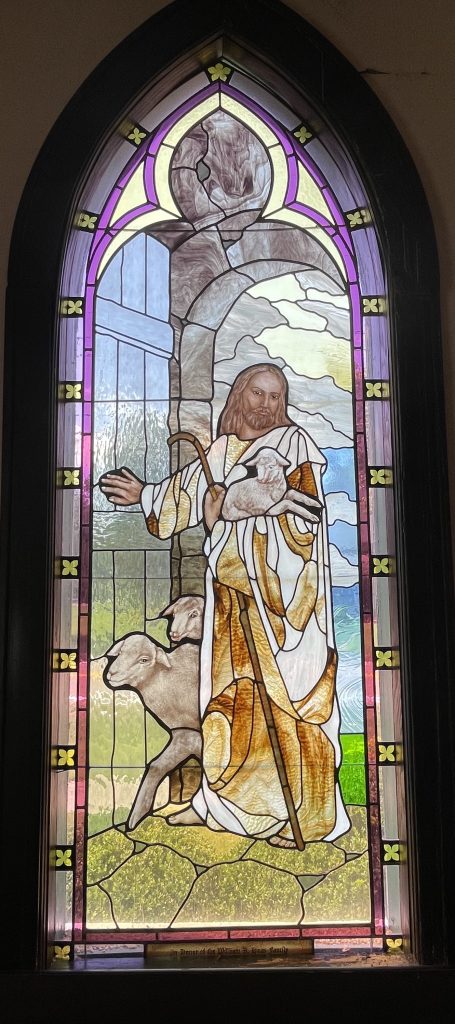 Stained glass window depicting Jesus holding a lamb